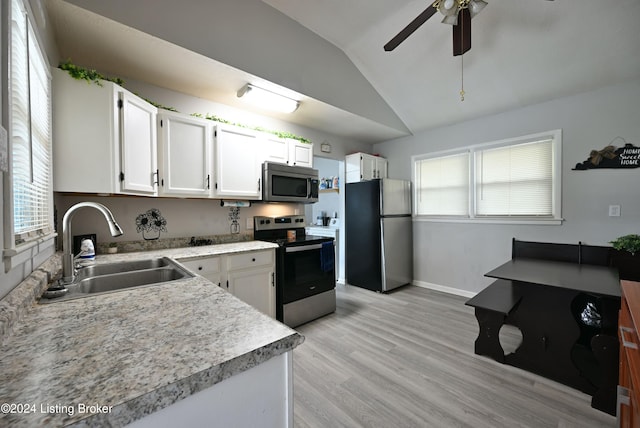 kitchen with white cabinets, lofted ceiling, sink, and stainless steel appliances