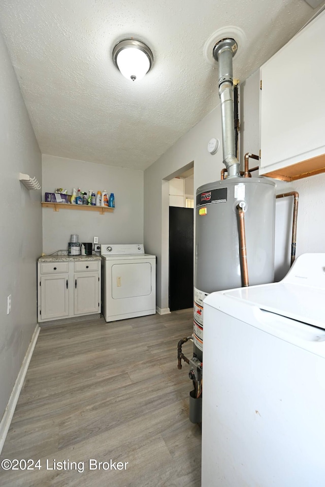 laundry room featuring cabinets, washer and dryer, a textured ceiling, and light hardwood / wood-style flooring