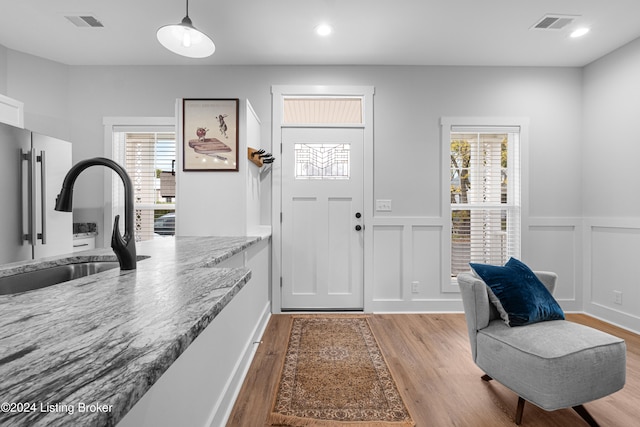 entrance foyer featuring a wealth of natural light, sink, and light hardwood / wood-style flooring