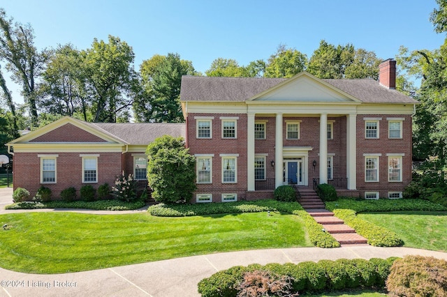 neoclassical / greek revival house featuring a front lawn