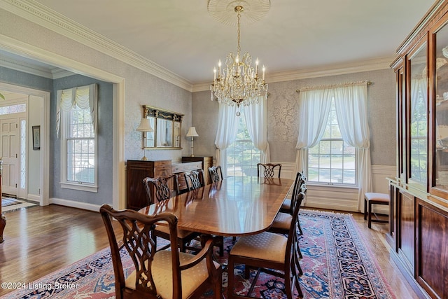 dining space with a chandelier, hardwood / wood-style floors, and ornamental molding