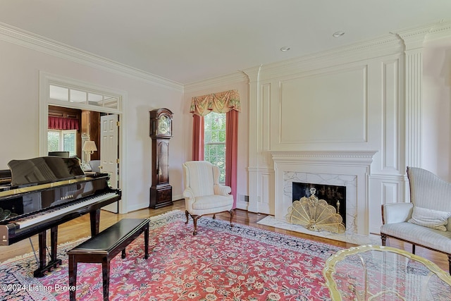 living area with a premium fireplace, light hardwood / wood-style flooring, and ornamental molding