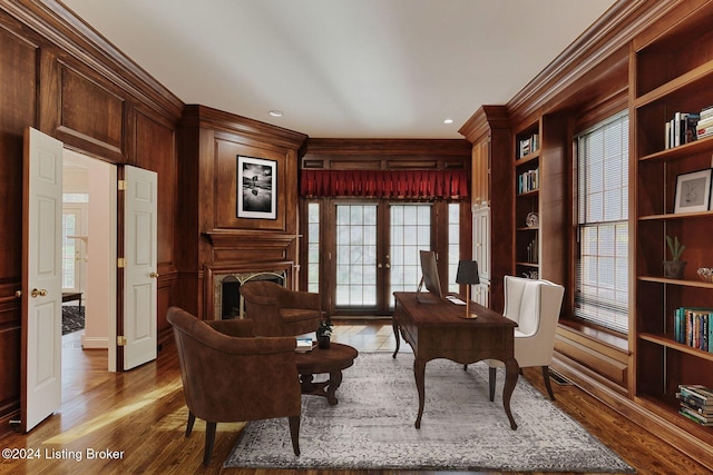 sitting room with wood-type flooring, ornamental molding, and french doors