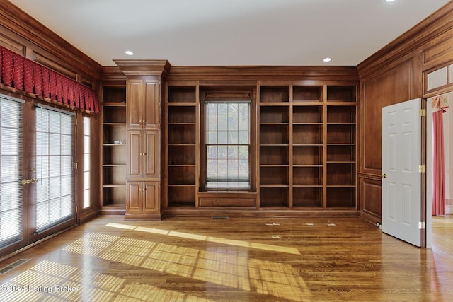 interior space with light hardwood / wood-style floors, a healthy amount of sunlight, and ornate columns