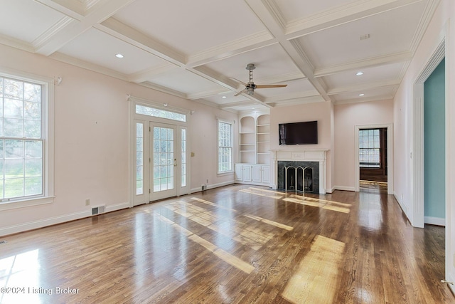 unfurnished living room featuring ceiling fan, wood-type flooring, and a healthy amount of sunlight