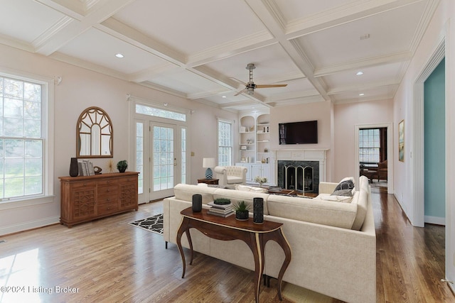 living room with a wealth of natural light, wood-type flooring, and ceiling fan