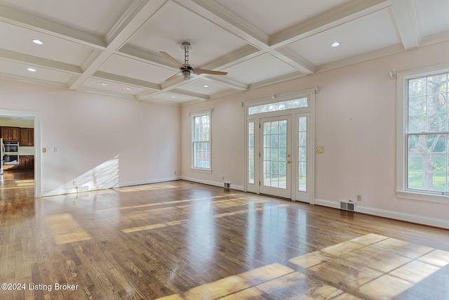 spare room featuring hardwood / wood-style flooring, beamed ceiling, and plenty of natural light