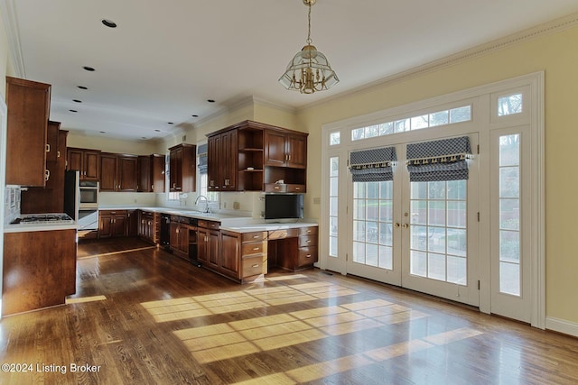 kitchen with ornamental molding, dark brown cabinets, a notable chandelier, dark hardwood / wood-style flooring, and hanging light fixtures