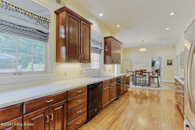 kitchen with hanging light fixtures, a healthy amount of sunlight, light hardwood / wood-style flooring, and crown molding