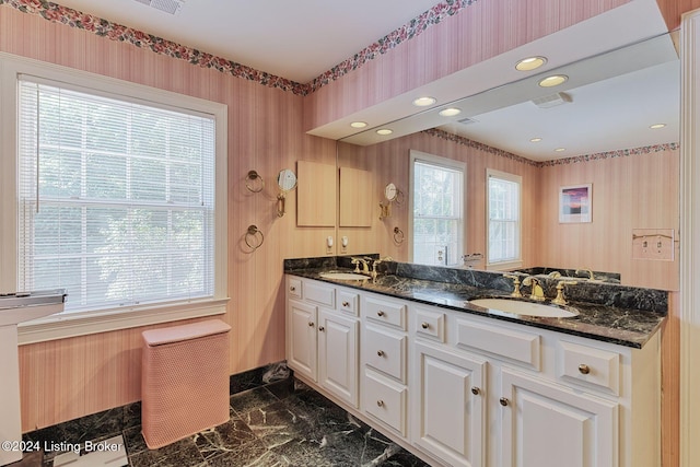 kitchen featuring a wealth of natural light, sink, and dark stone countertops