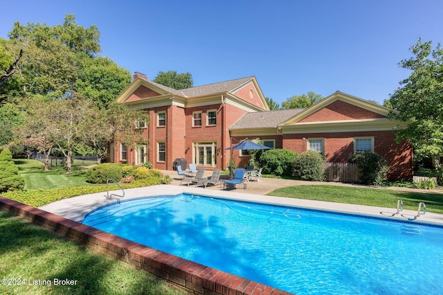 view of pool featuring a patio and a yard