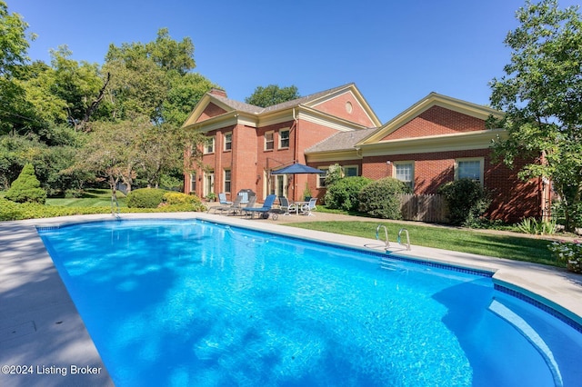 view of pool featuring a patio and a yard