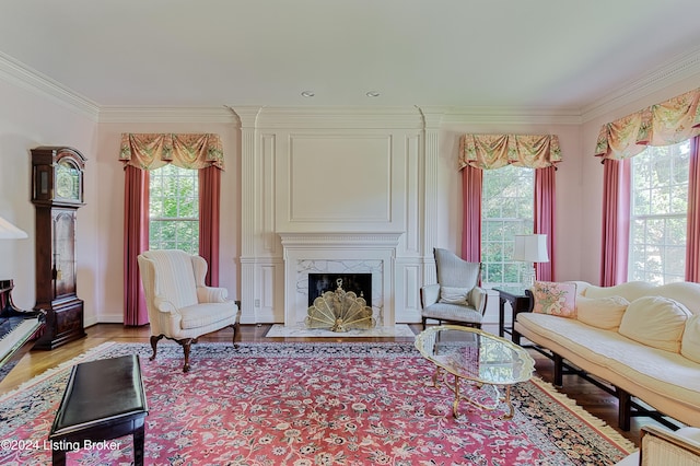 living room featuring a high end fireplace, crown molding, and light hardwood / wood-style flooring