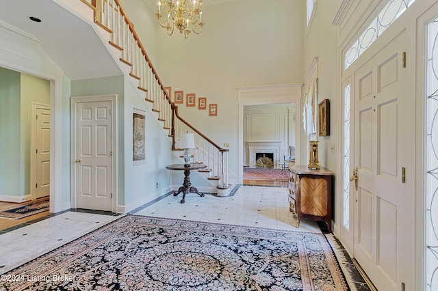 entrance foyer featuring ornamental molding, a high ceiling, and an inviting chandelier