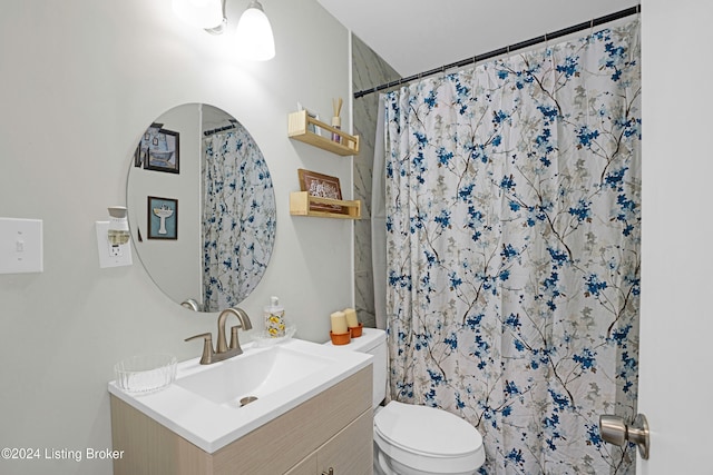 bathroom featuring curtained shower, vanity, and toilet