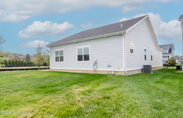 view of side of property featuring a lawn and cooling unit