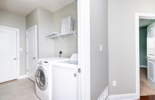 laundry area featuring light tile patterned floors and washer and clothes dryer