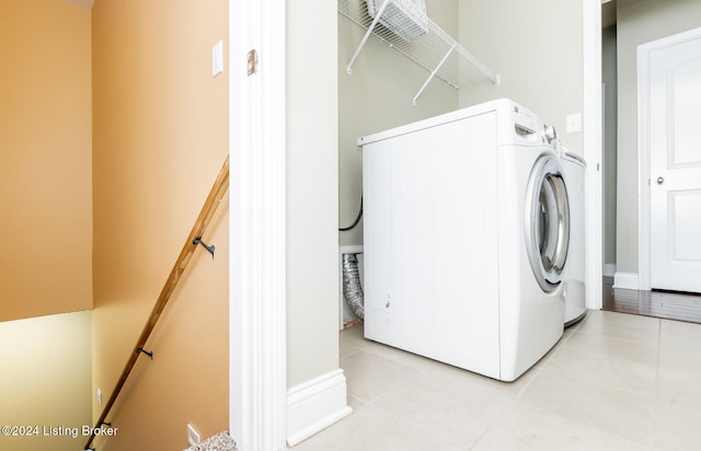 clothes washing area featuring light tile patterned floors and washer / clothes dryer