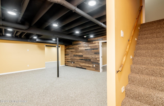 basement with carpet floors and wood walls