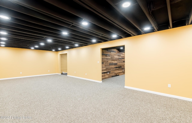 basement with wood walls and carpet flooring