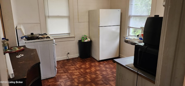 kitchen featuring white appliances and dark parquet flooring