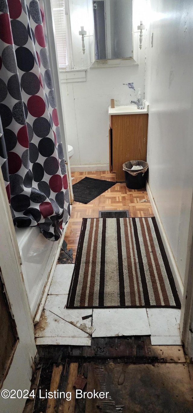 bathroom with hardwood / wood-style flooring, toilet, and sink