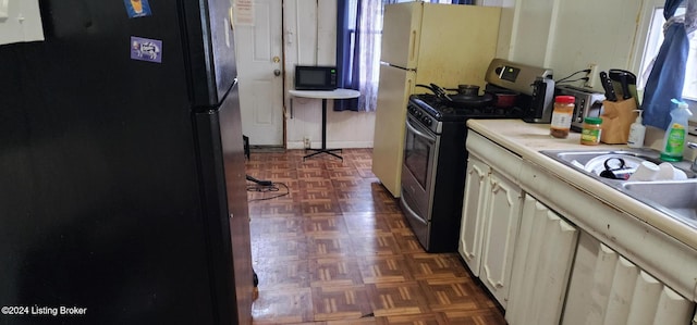 kitchen featuring black appliances and dark parquet flooring