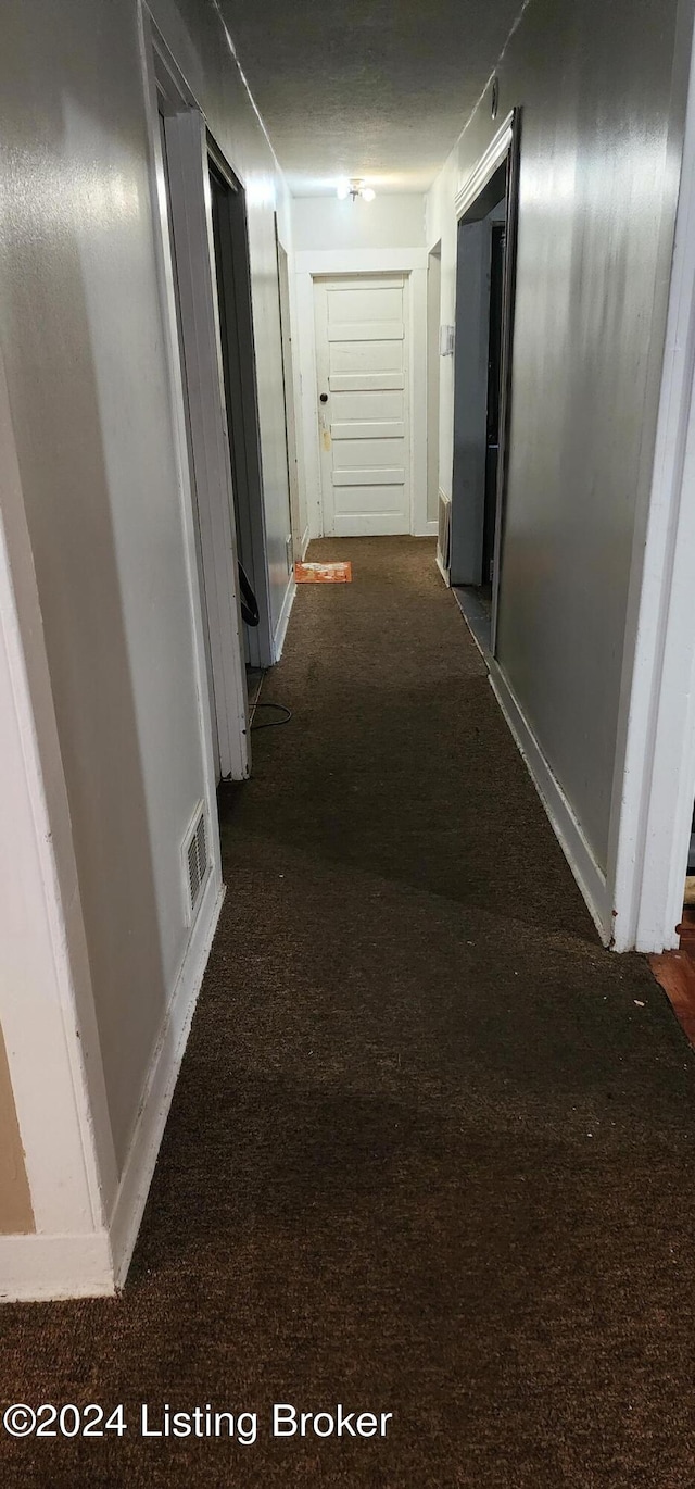 corridor with dark colored carpet