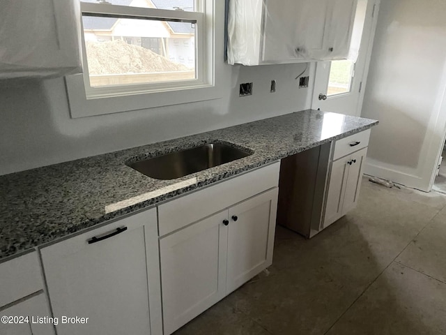 kitchen featuring light stone countertops and white cabinets