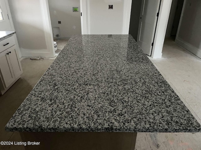 interior space with white cabinets and dark stone countertops