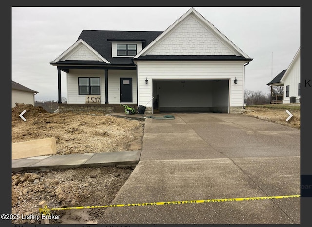 view of front of property featuring covered porch, driveway, and an attached garage