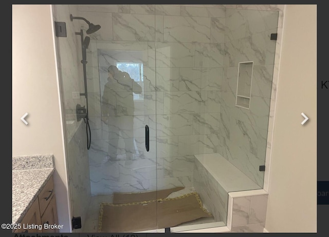 full bathroom featuring vanity and a marble finish shower