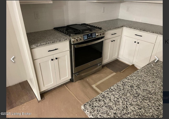 kitchen with gas stove, decorative backsplash, light wood-style flooring, and white cabinets