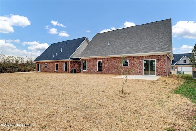 rear view of property with a patio, a garage, a yard, and cooling unit