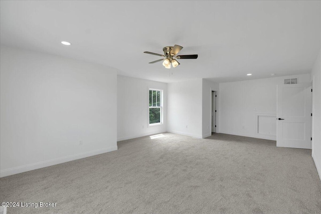 unfurnished room with ceiling fan and light carpet