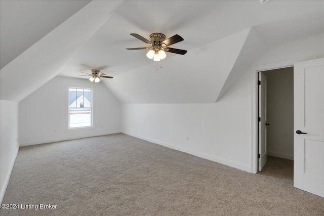 additional living space featuring ceiling fan, lofted ceiling, and light colored carpet