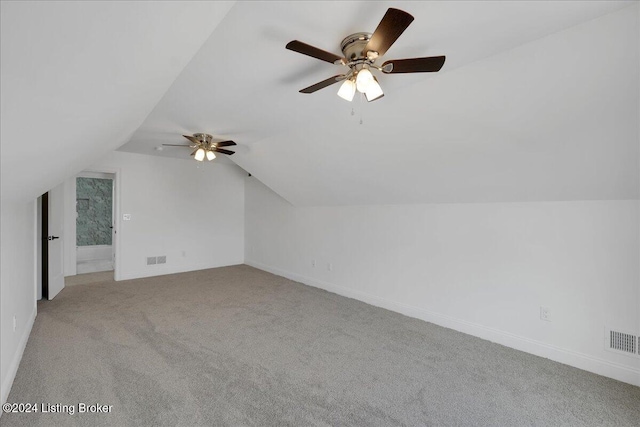 additional living space with light colored carpet, ceiling fan, and vaulted ceiling