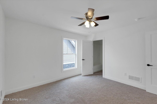 spare room featuring light colored carpet and ceiling fan