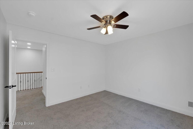 carpeted spare room featuring ceiling fan