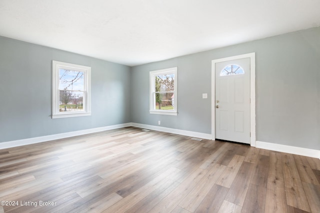 foyer entrance with light wood-type flooring and a healthy amount of sunlight