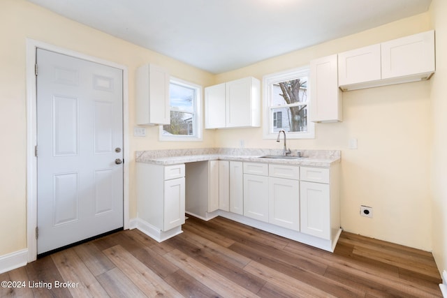 kitchen featuring white cabinets, sink, and light hardwood / wood-style flooring