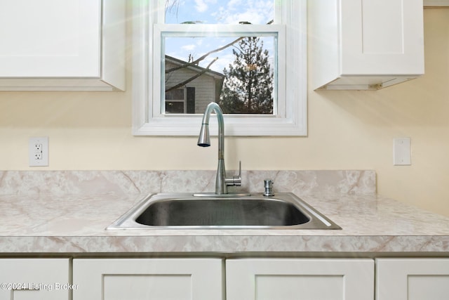 interior details featuring white cabinetry and sink