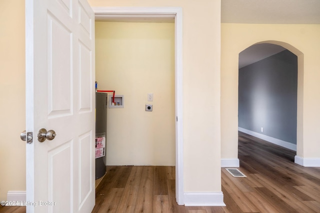 laundry area featuring water heater, washer hookup, hardwood / wood-style flooring, and electric dryer hookup