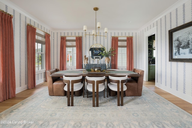 dining room featuring wood-type flooring, a notable chandelier, and ornamental molding