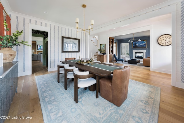 dining room featuring hardwood / wood-style floors, ornamental molding, and a notable chandelier