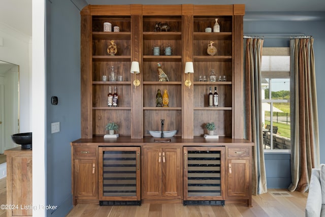 bar featuring wine cooler and light wood-type flooring