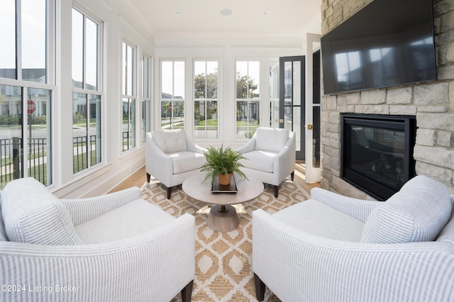 sunroom / solarium featuring a stone fireplace