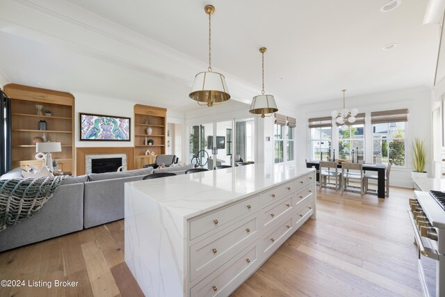 kitchen with white cabinets, hanging light fixtures, and light wood-type flooring