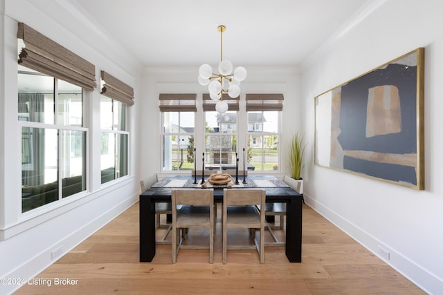 dining area with an inviting chandelier, light wood-type flooring, and ornamental molding