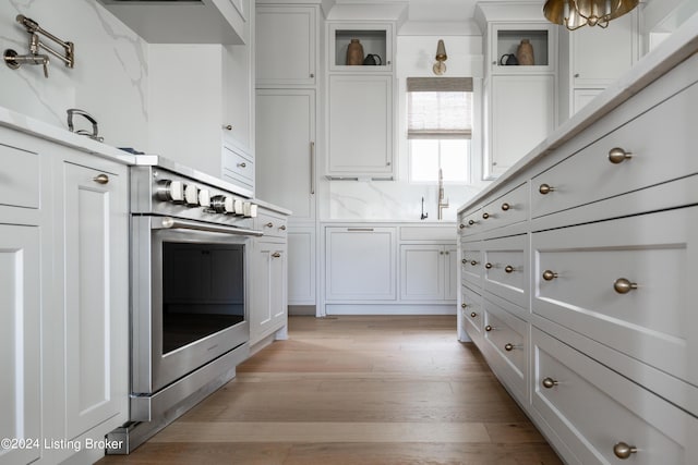 kitchen featuring white cabinetry, stainless steel range, and light hardwood / wood-style flooring